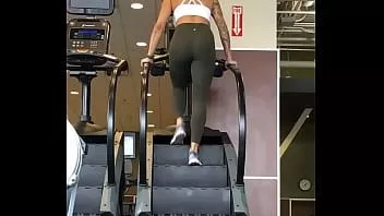 Abspielen Fittes tätowiertes Babe zeigt Arsch in Leggings auf Laufband